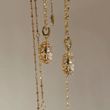 Close-up of two 10 carat oval cut solitaire pendants in silver and rose gold, showcasing the intricate and secure basket setting.