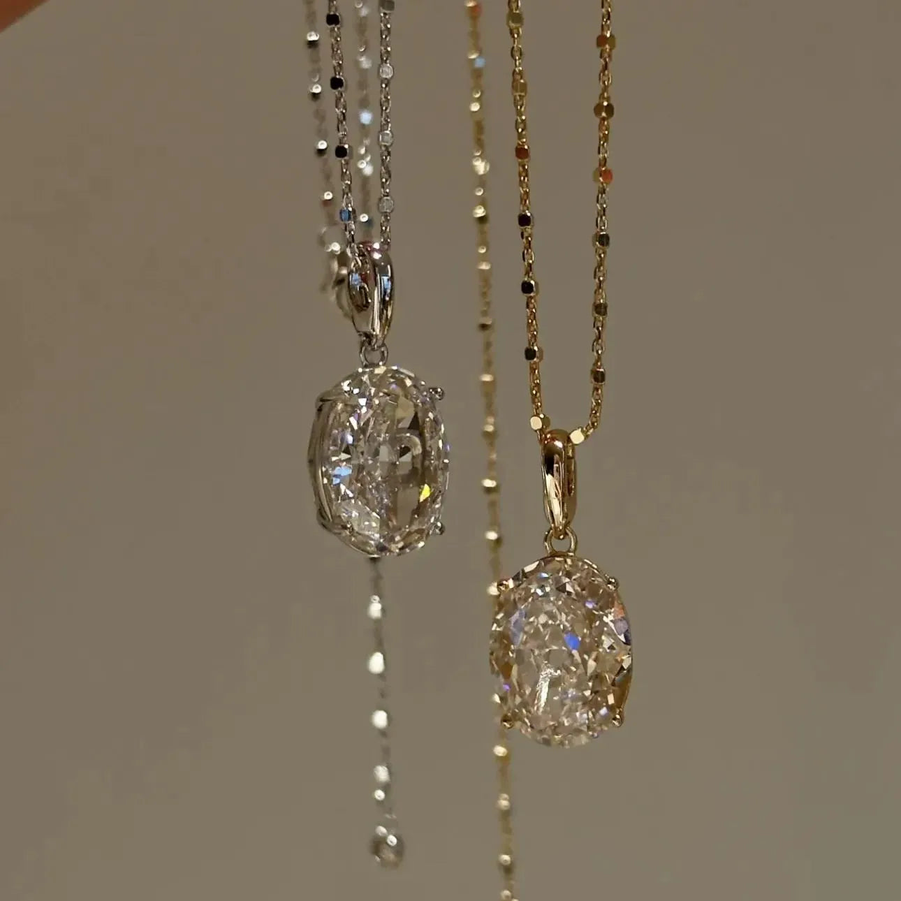 Side-by-side comparison of the 10 carat oval pendant necklaces in 925 sterling silver and rose gold finish.