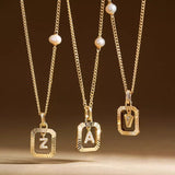 A 14K gold plated vintage pearl initial necklace resting elegantly on soft, textured white fabric.