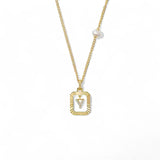 A 14K gold plated vintage rectangular sunburst pendant featuring a dancing pave initial letter Y and a side freshwater pearl, isolated on a white background.
