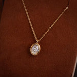 Detailed angled shot of the "bathtub" style thick gold bezel encasing the brilliant oval lab-grown diamond.