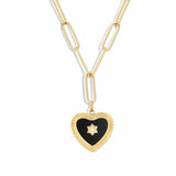 An 18K gold plated lariat necklace laid flat on a white background, showing a paperclip chain dropping into a Y-shape, ending with a black enamel heart pendant featuring a ribbed gold border and a central star motif.