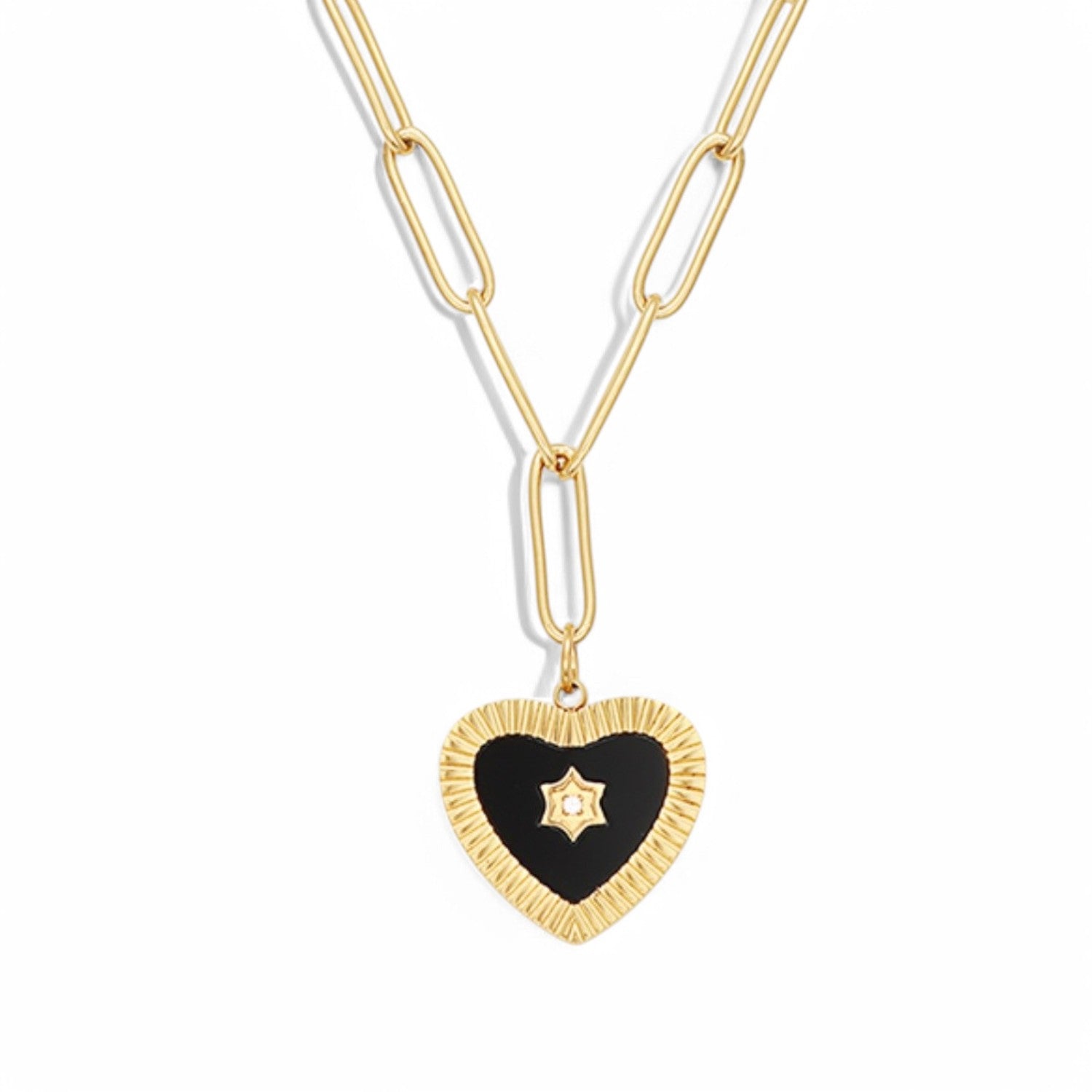 An 18K gold plated lariat necklace laid flat on a white background, showing a paperclip chain dropping into a Y-shape, ending with a black enamel heart pendant featuring a ribbed gold border and a central star motif.