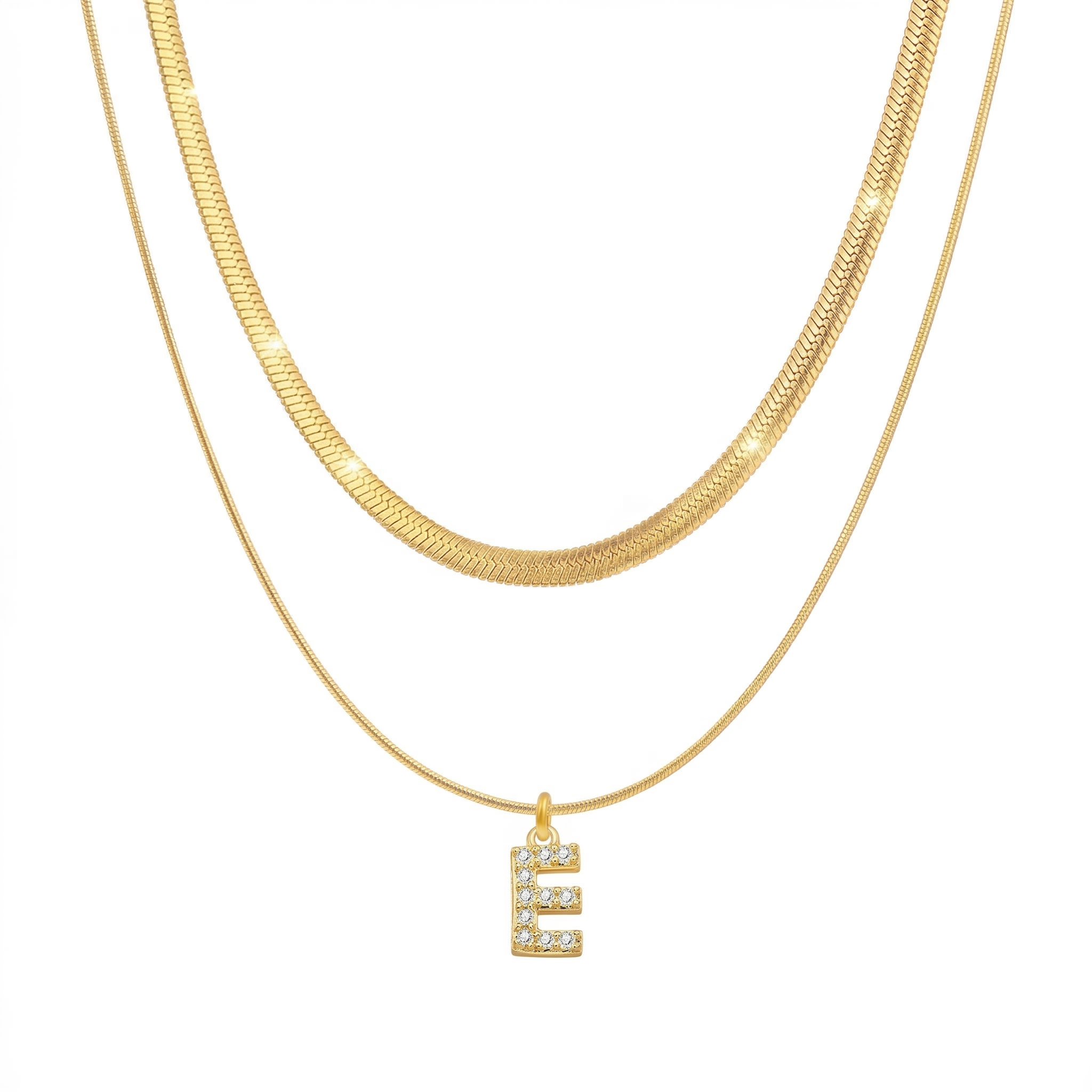 Two 18K gold plated necklaces layered together, featuring a flat snake chain and a matching chain with a pave initial E pendant, isolated on a clean white background.