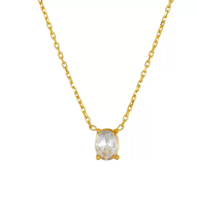 Flat lay of a single 18k gold plated dainty chain necklace featuring a solitary, brilliant oval cut simulated diamond pendant.