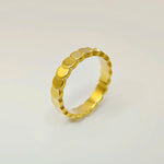 Close-up studio shot of an 18k gold overlapping disc ring standing upright against a crisp white background.