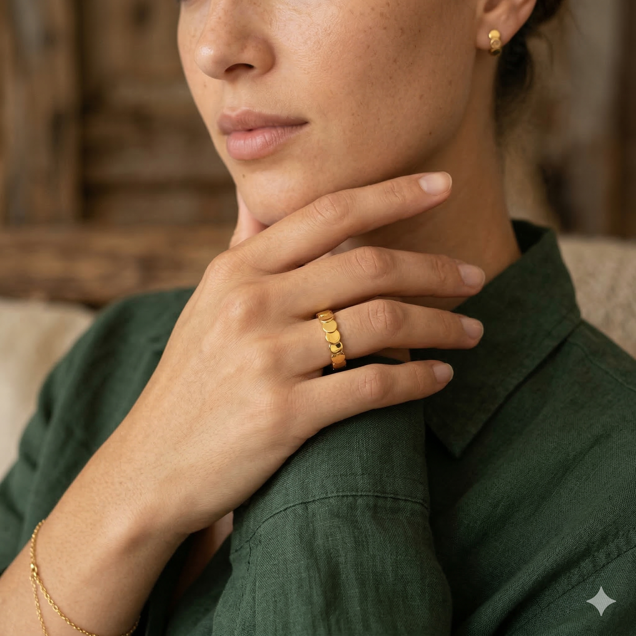 Close-up of a model in a green shirt touching her neck, wearing a chic 18k gold plated continuous circle stacking band.