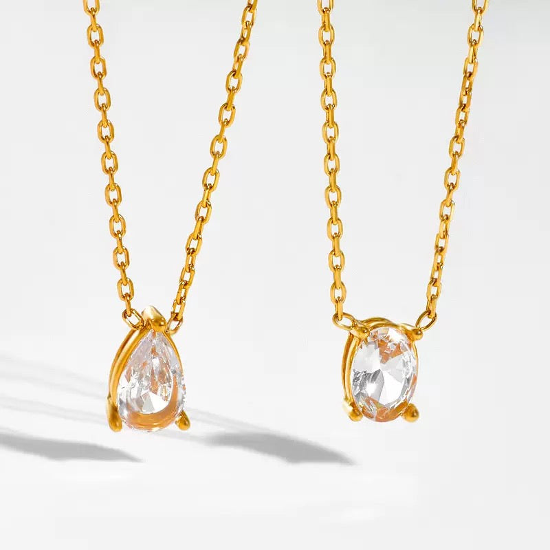 Two 18k gold plated dainty necklaces displayed side-by-side on a flat surface, showing both the oval and teardrop pendants.