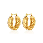 Professional product shot of 18K gold-plated quilted hoop earrings with a distinctive textured surface.