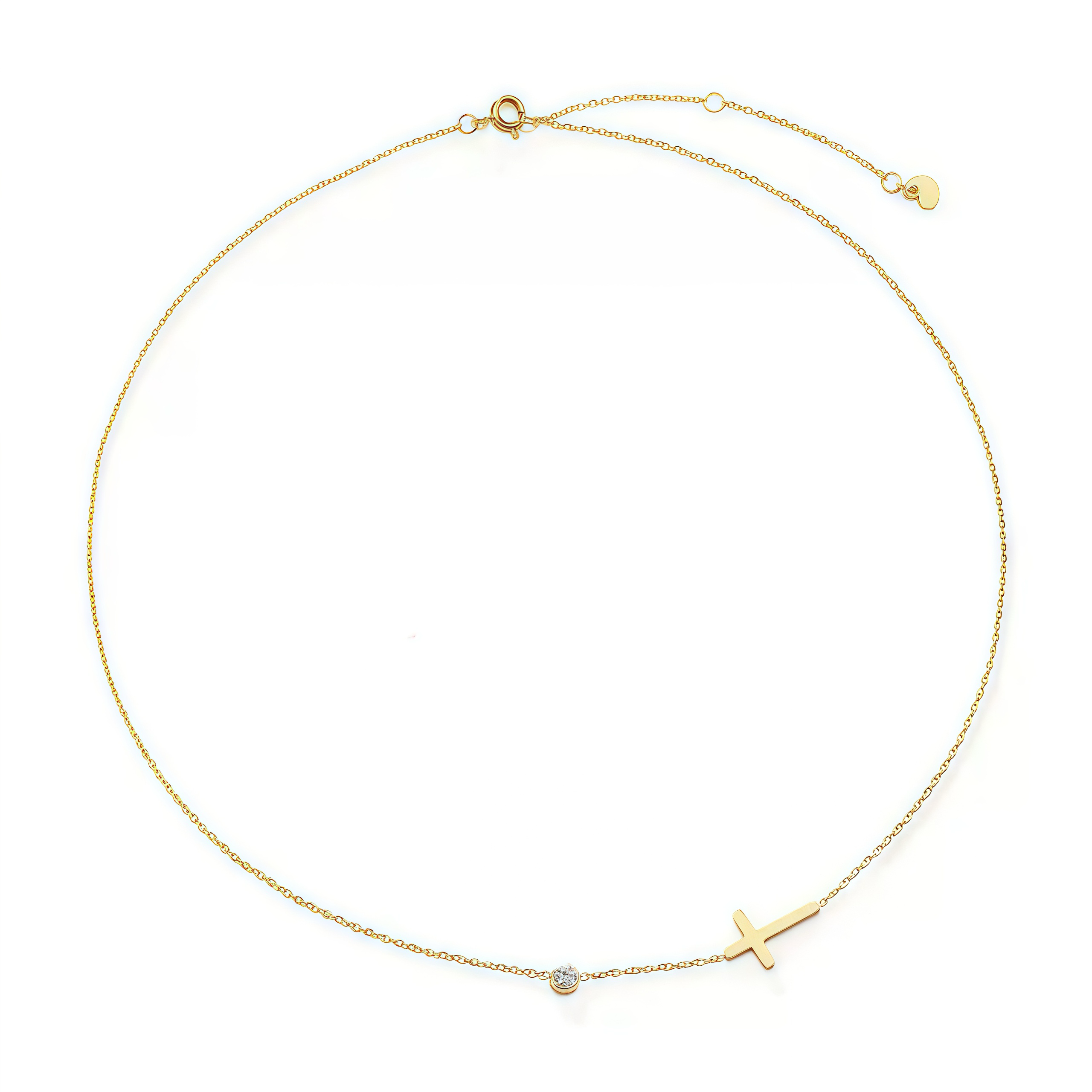 Flat lay of the 18K gold sideways cross necklace displayed on a textured stone background.