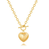 A shiny 18K gold ribbed puffy heart pendant on a chunky cable chain with a front toggle clasp, isolated on a white background.