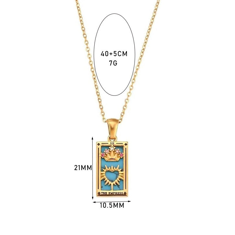 An 18K gold plated tarot card rectangular pendant labeled THE EMPRESS, featuring a turquoise enamel background, a gold crown with pink stones, and a sunburst heart. Graphic text indicates dimensions of 21mm by 10.5mm and a 40 plus 5cm chain weighing 7g.