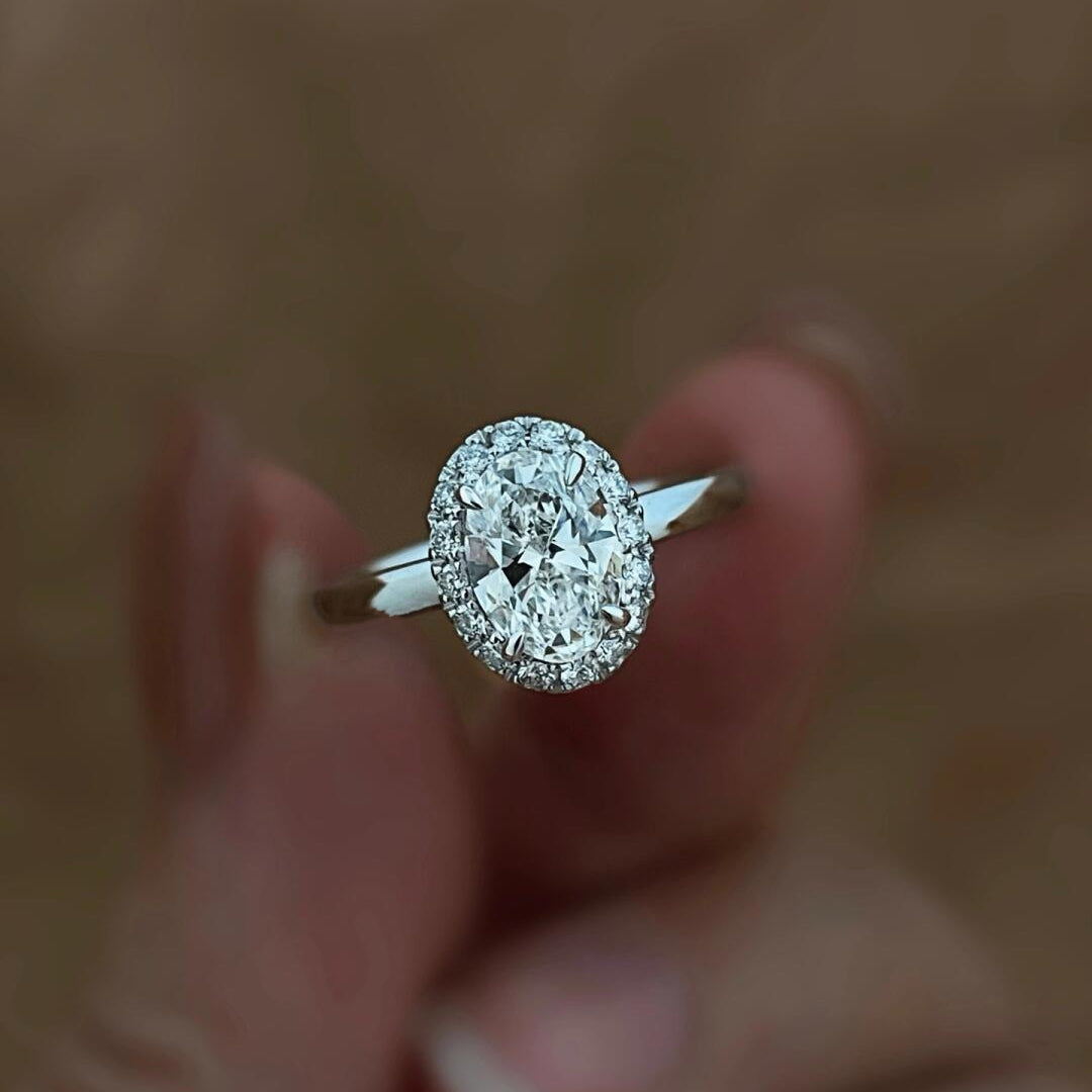 A brilliant 2.06 ct oval lab-grown diamond ring featuring a delicate diamond halo, set in polished PT950 platinum.