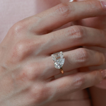 Close-up of the Twin Aura ring showcasing the icy-white DE color and VS clarity of the emerald and pear diamonds.