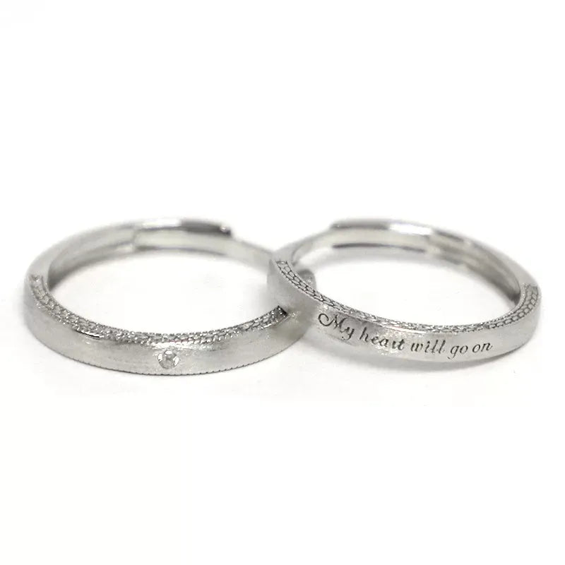 A pair of 925 sterling silver adjustable couple rings on a pure white background, clearly displaying the open-back design and custom engraving.