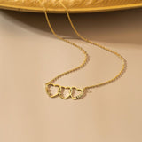 Gold necklace with heart-shaped pendants on a beige background