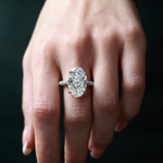 Close-up view of the oversized oval lab diamond ring, highlighting the luxurious triple-row micro-pavé eternity band.