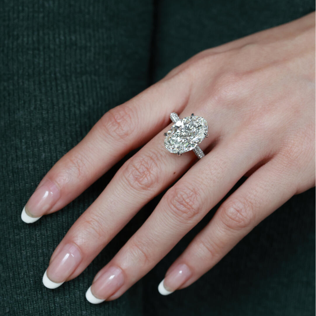 A woman wearing the breathtaking D VVS2 oval lab diamond ring in solid PT950 platinum on her ring finger.