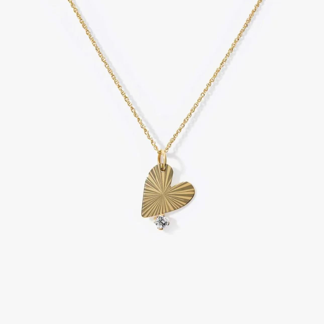 Gold necklace with a heart-shaped pendant on a white background