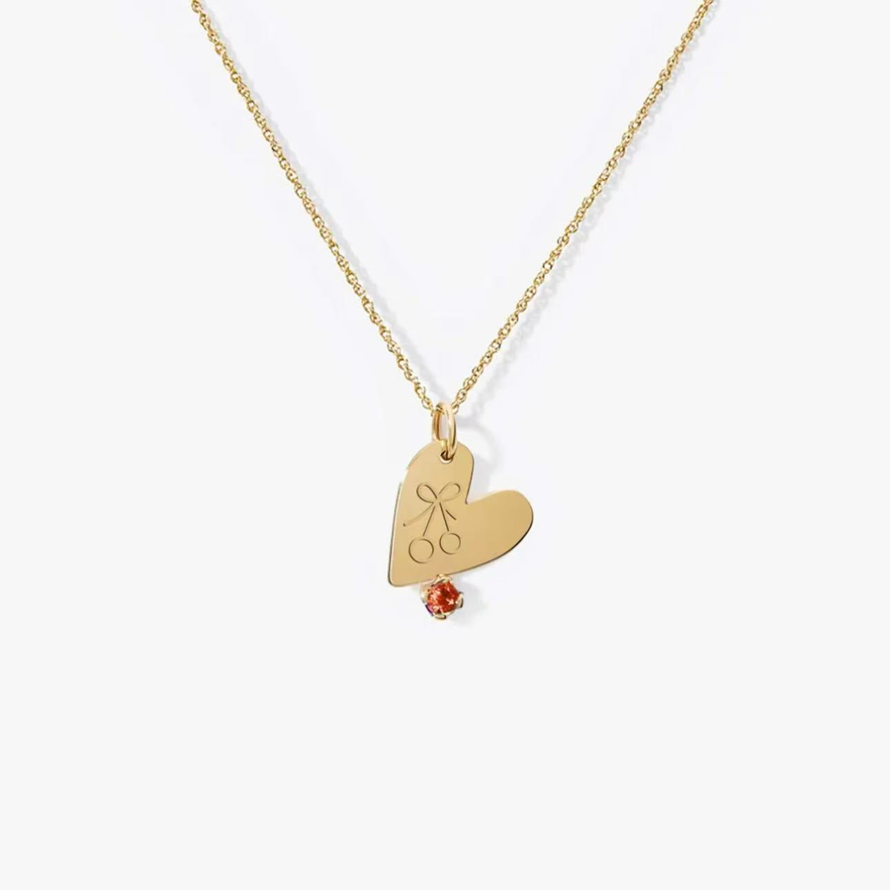 Playful cherry engraved gold heart necklace with a red gem detail