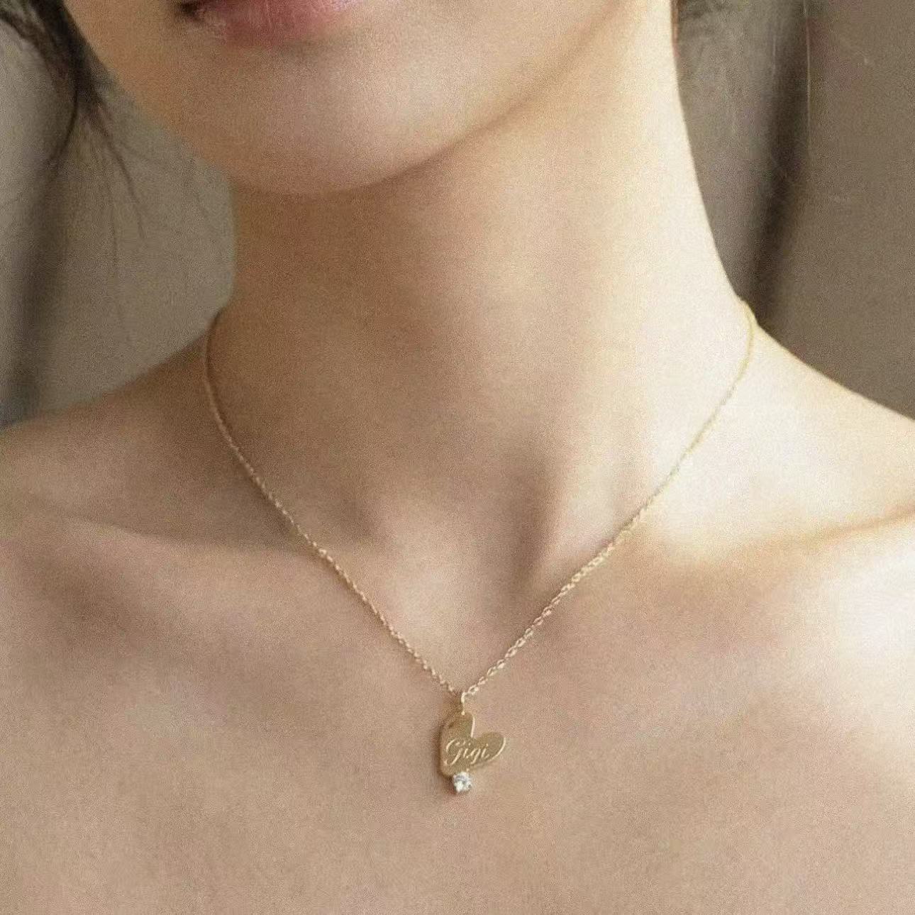 Gold necklace with a heart-shaped pendant on a person's neck