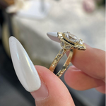 Detailed view of the E-F color VVS2 marquise center stone surrounded by a scalloped halo on a warm gold setting.