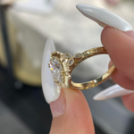 Detailed view of the E-F color VVS2 marquise center stone surrounded by a scalloped halo on a warm gold setting.