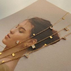 18K gold plated Glisten Gemstone station necklace isolated on a clean white background.