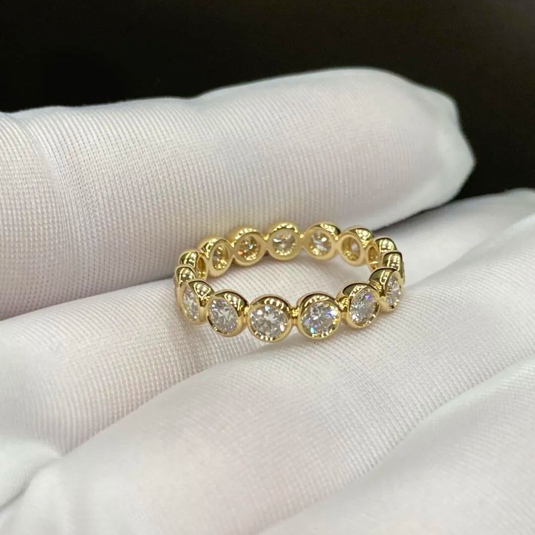 Gold ring with embedded diamonds on a white fabric background
