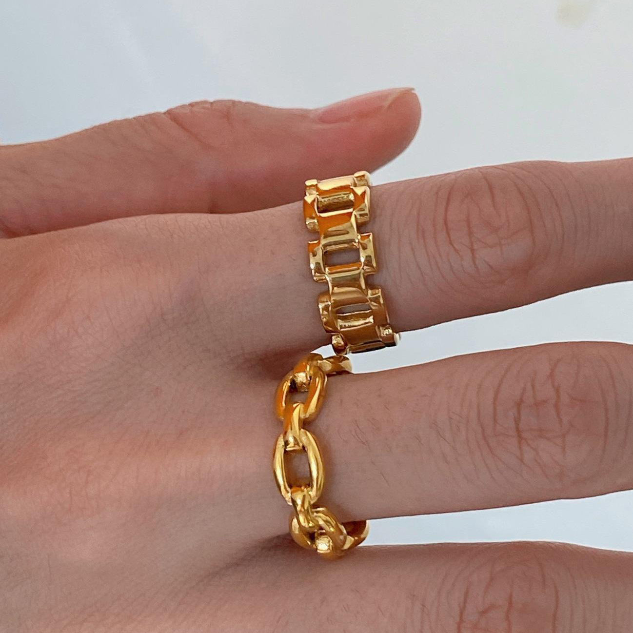 A model wearing the Chain Link Ring stacked with another gold band to showcase a layered jewelry look.