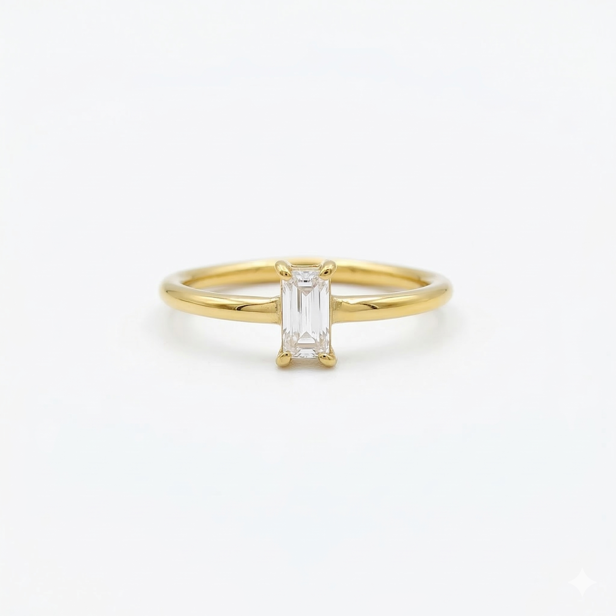 A classic minimalist gold solitaire ring featuring a clear emerald-cut cubic zirconia set vertically, isolated on a clean white background.