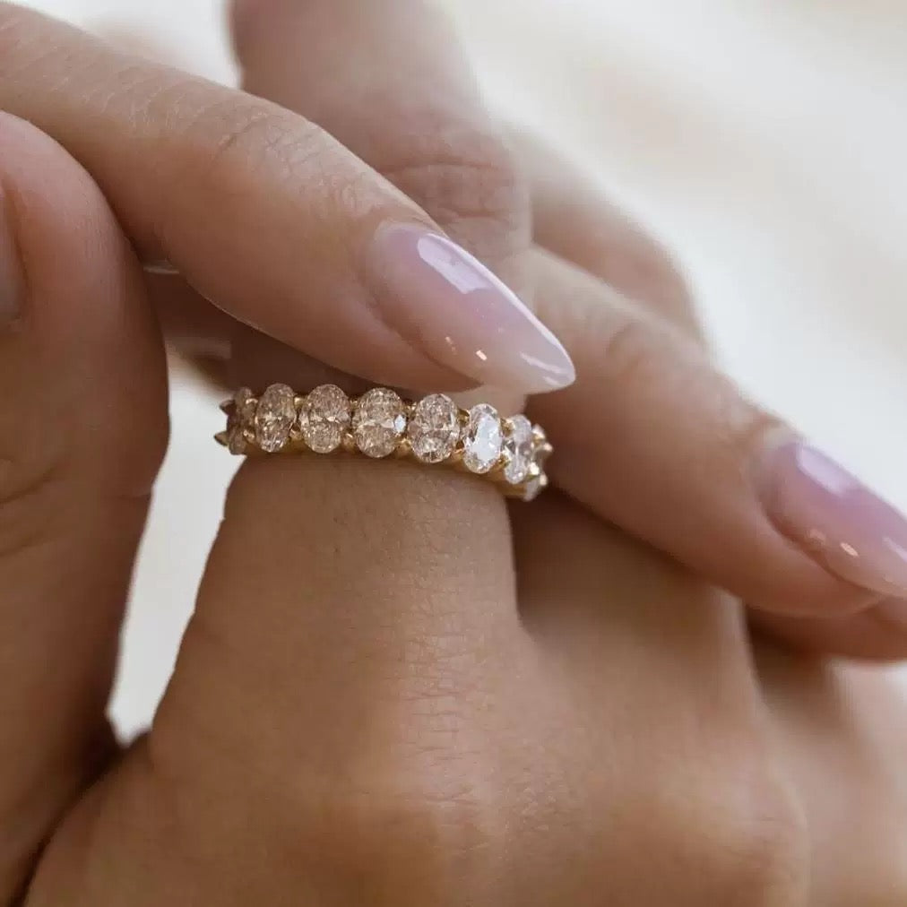 A model wearing the classic 18K gold oval lab diamond eternity ring on her finger, displaying its flattering silhouette.