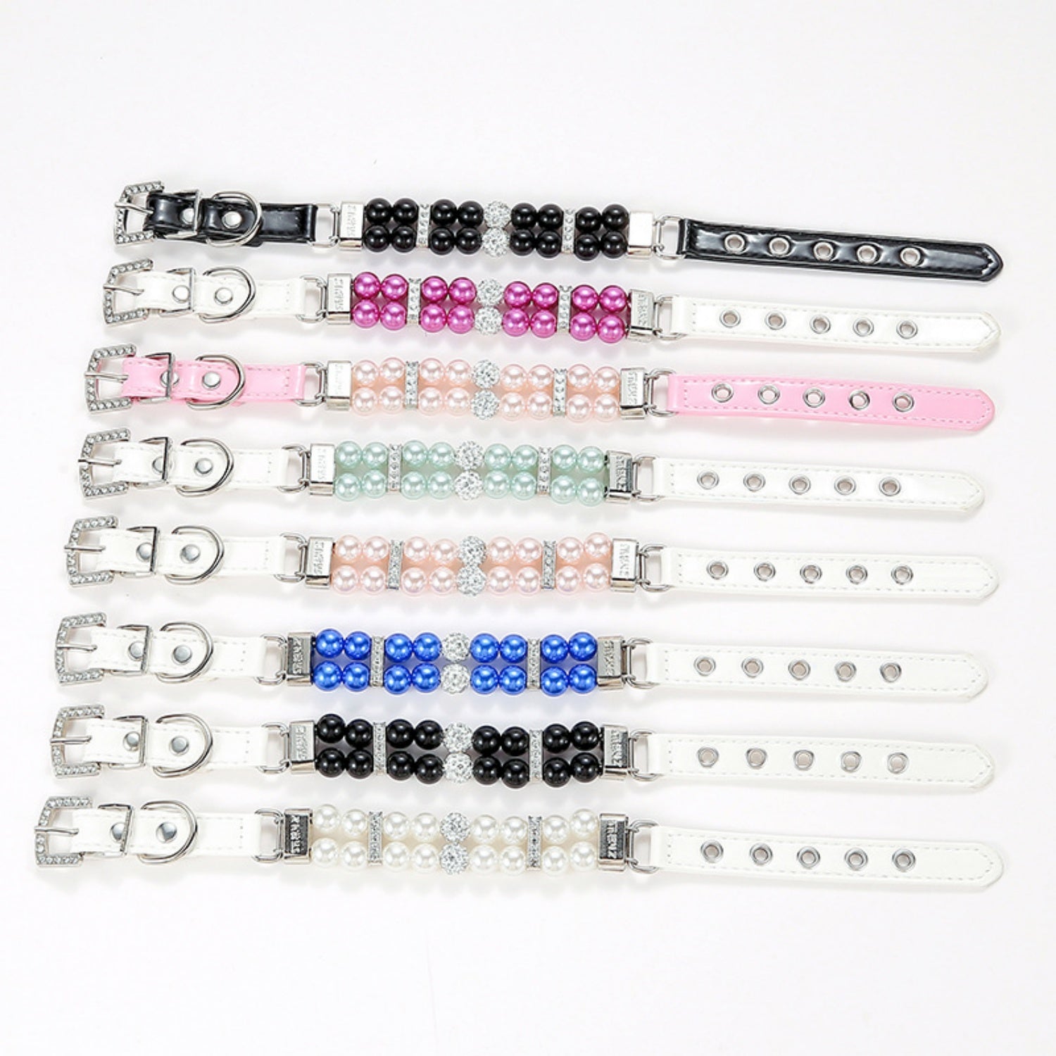 A collection of eight simulated pearl pet collars in various colors including black, hot pink, light pink, mint green, royal blue, and white, laid flat horizontally against a white background.