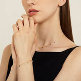 Close-up of the dainty rainbow cubic zirconia necklace resting on a model's collarbone.