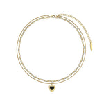 Studio product photo of a pre-stacked 18K gold-plated necklace with a black heart pendant and paperclip link chain.