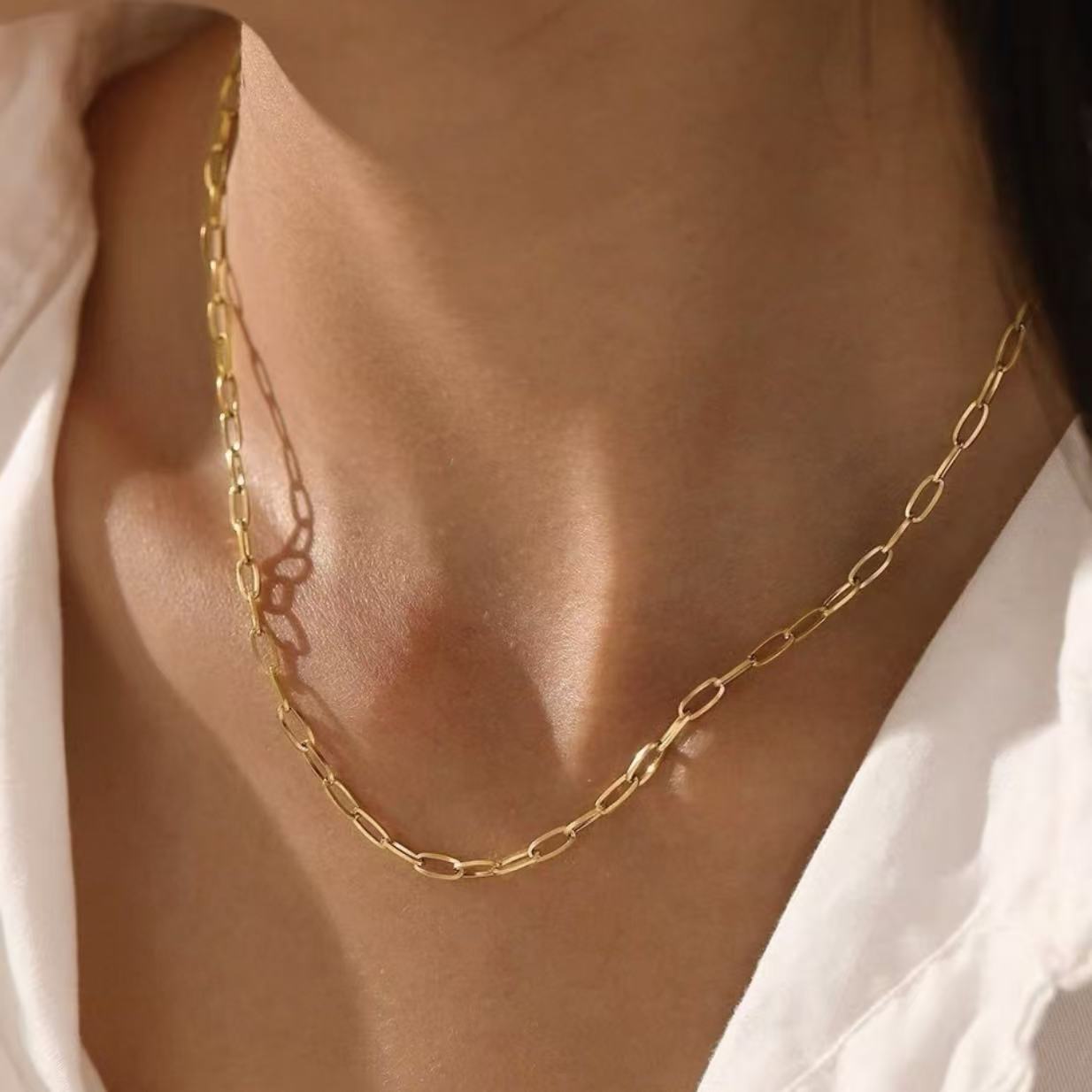 A model wearing the Essential 3mm 18K gold plated paperclip chain necklace, resting perfectly on the collarbone.