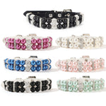 Six elegant pearl and rhinestone pet collars in black, hot pink, white, royal blue, light pink, and mint green displayed in a semi-circle on a white surface.