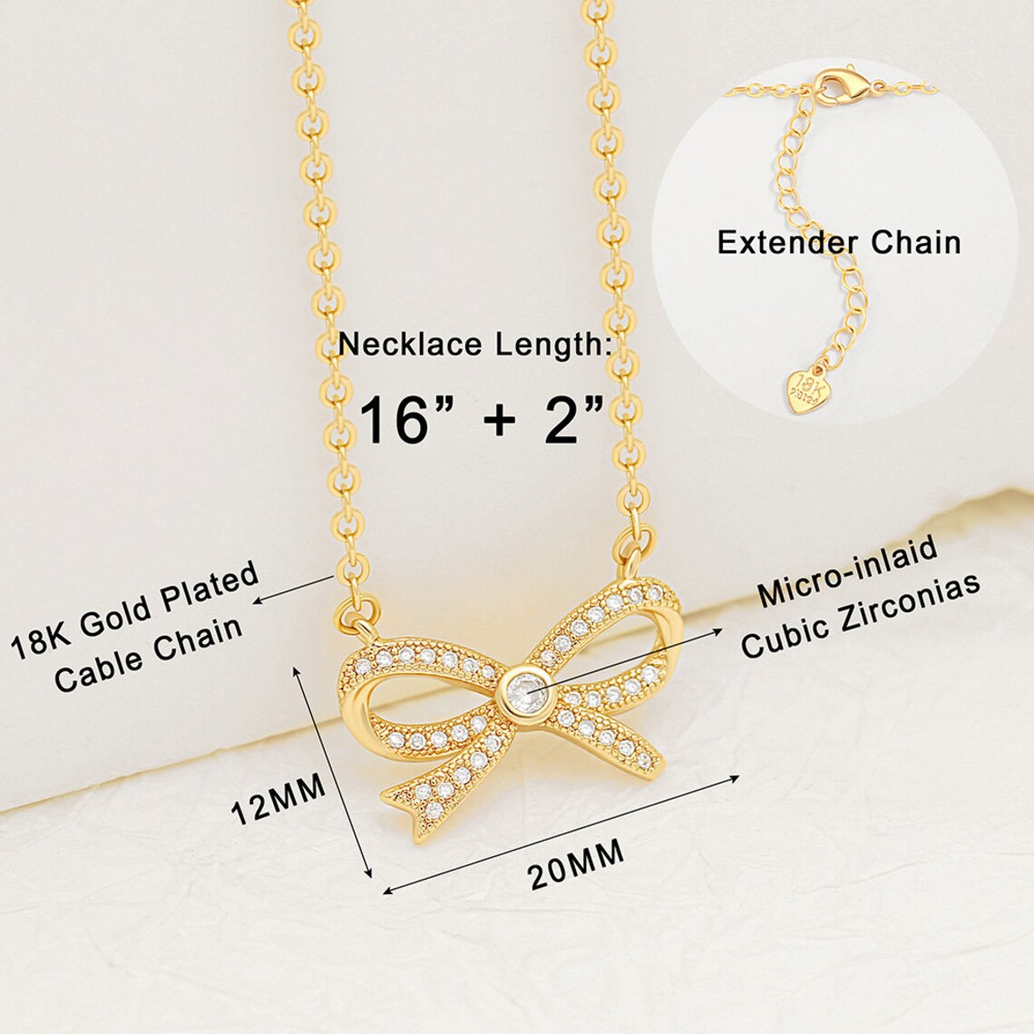 Dimensions and specifications of the 18K gold plated bow necklace, showing a 20mm by 12mm pendant, micro-inlaid cubic zirconias, and a 16 plus 2 inch extender chain.