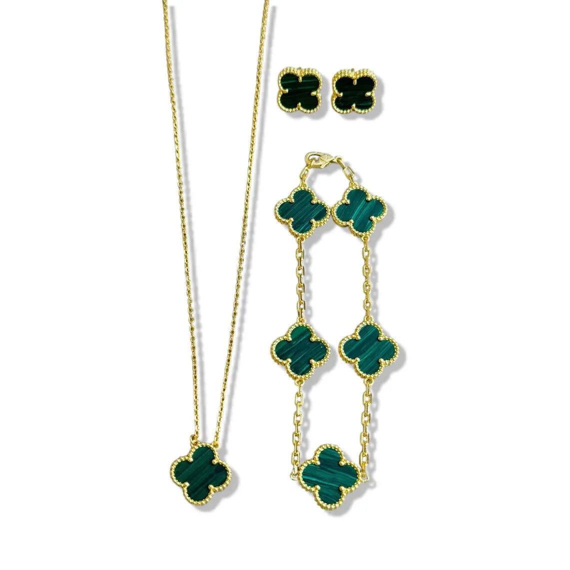 An elegant 18K gold plated jewelry set featuring a black four-leaf clover necklace, matching bracelet, and stud earrings laid on a white background.