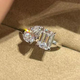 Close-up shot of the sparkling 1.5ct emerald and 1.5ct pear cut high-carbon diamonds on the Toi et Moi ring resting in a box.