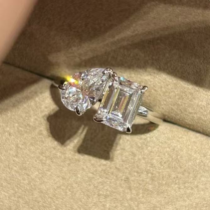 Close-up shot of the sparkling 1.5ct emerald and 1.5ct pear cut high-carbon diamonds on the Toi et Moi ring resting in a box.