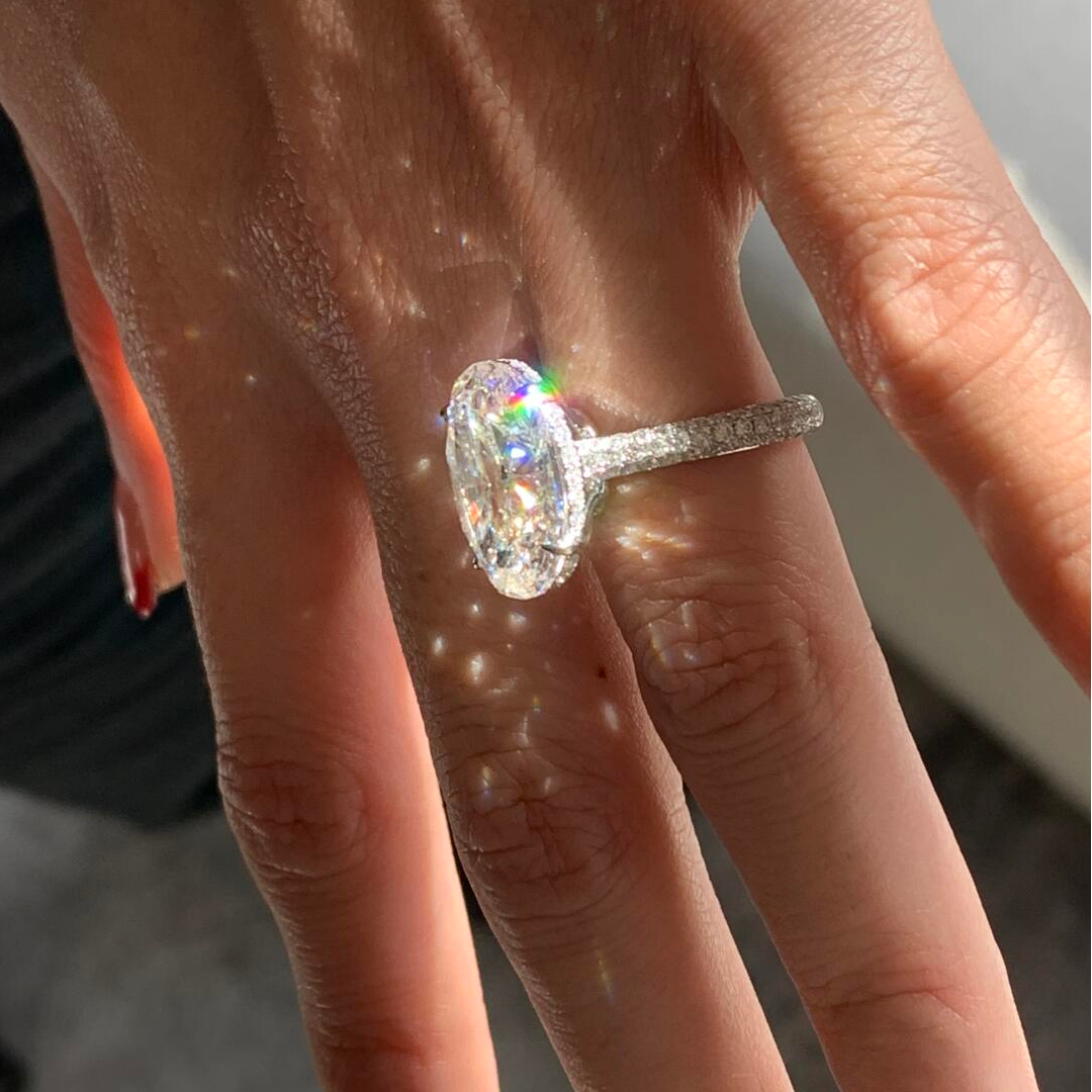 The mesmerizing Light Bulb Spark lab diamond ring refracting rainbow fire under direct sunlight, featuring an oversized oval center stone.