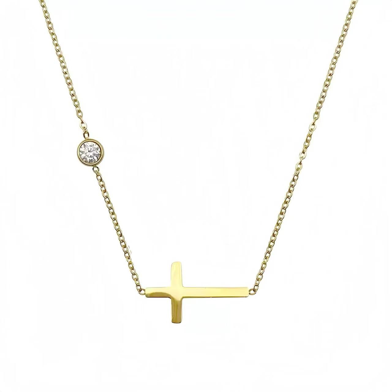 The complete delicate gold chain featuring an off-center sideways cross, shown against a clean white background.