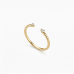A high-quality product shot of a minimalist 18K gold-plated open cuff gap ring with two sparkling stones.