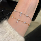 A stylish wrist wearing both the 925 silver and 14K rose gold plated dainty clover charm bracelets, showcasing a trendy mixed-metal stack.