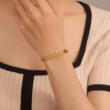 A woman casually wearing a personalized gold birth flower string bracelet on her wrist, highlighting the adjustable fit.