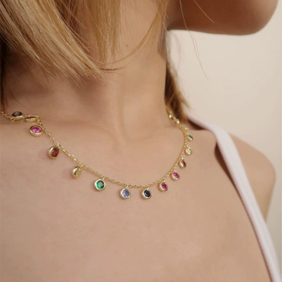 Detail shot of the rainbow cubic zirconia shaker necklace resting beautifully on a model's collarbone.