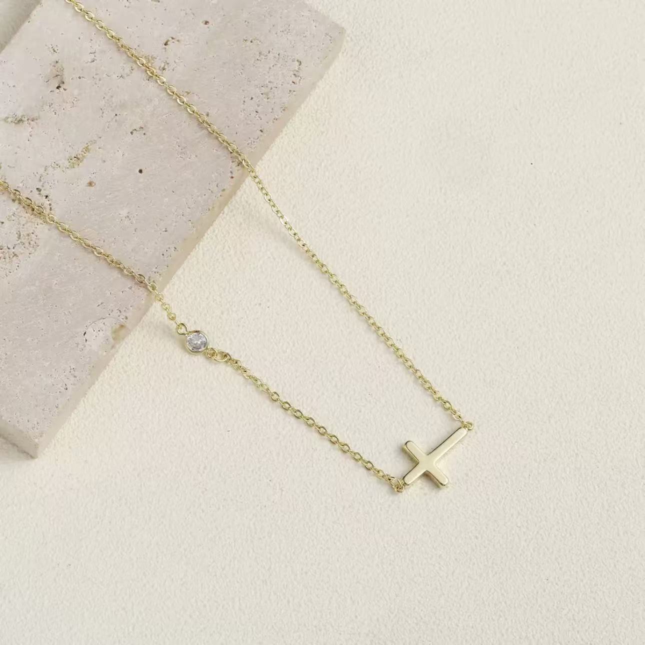 Detailed macro shot of the sleek 9x15mm gold cross and the brilliant bezel-set AAA cubic zirconia.