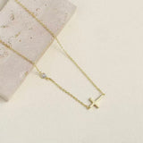 Detailed macro shot of the sleek 9x15mm gold cross and the brilliant bezel-set AAA cubic zirconia.