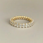 A close-up of the 18K gold Oval Lab Diamond Eternity Band standing upright against a soft white background, showcasing its uninterrupted sparkle.